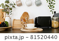Cute red kitten playing on the kitchen table. Little ginger striped cat siting on table and looking up at camera 81520440