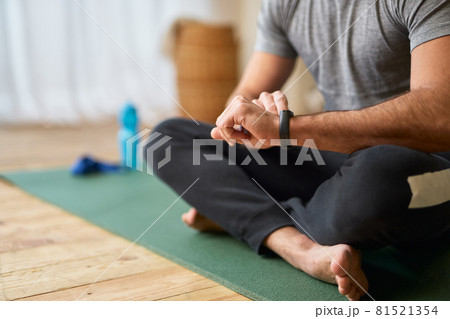 Young man checking time on smartwatch at home Young man checking time on smartwatch at home 81521354