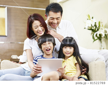 asian parents and children sitting on couch having fun with digital tablet asian parents and children sitting on couch having fun with digital tablet 81522769
