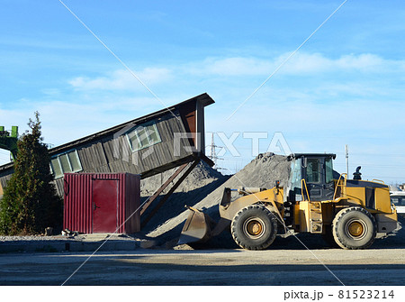 Wheel loader at construction site. Fron-end loader unloads crushed stone  81523214