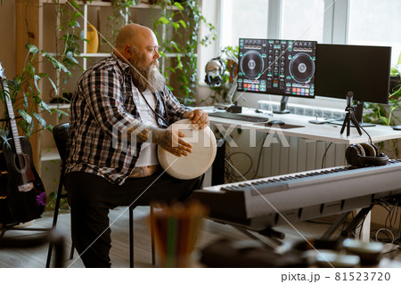 Positine obese man plays drum sitting in home audio record studio 81523720