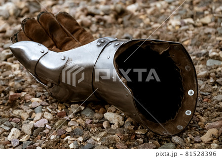 Metallic gauntlet as part of knight equipment abandoned on the ground 81528396