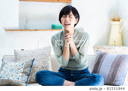 手を組んで祈る若い女性 81531944