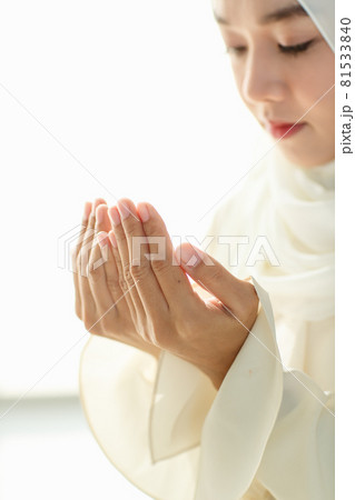 Young and beautiful Asian Muslim woman rise hands and praying with respect and calm manner 81533840