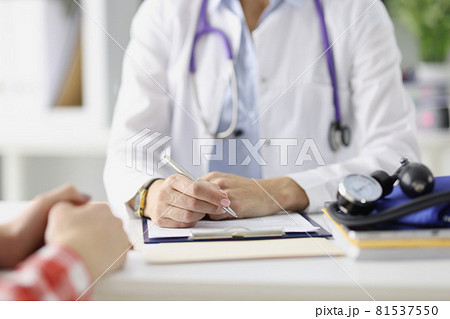 Doctor sitting at table and preparing medical records with ballpoint pen closeup Doctor sitting at table and preparing medical records with ballpoint pen closeup 81537550
