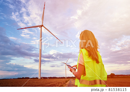 Engineer looks at wind turbine in the field Engineer looks at wind turbine in the field 81538115