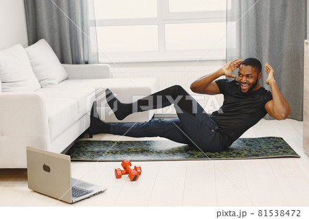 Handsome Afro American sportsman working out at home Handsome Afro American sportsman working out at home 81538472