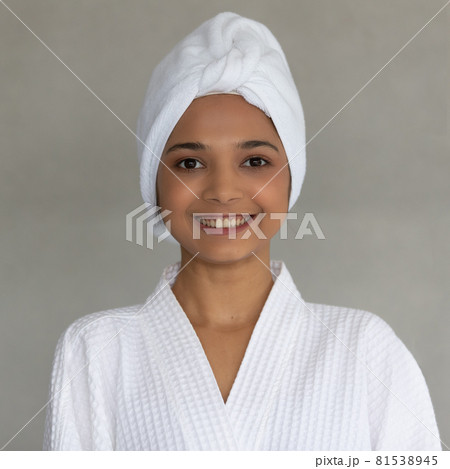 Cute teen Asian woman with white towel folding around head in white spa dress Cute teen Asian woman with white towel folding around head in white spa dress 81538945