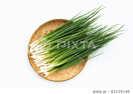Spring onions in bamboo basket on white background 81539146
