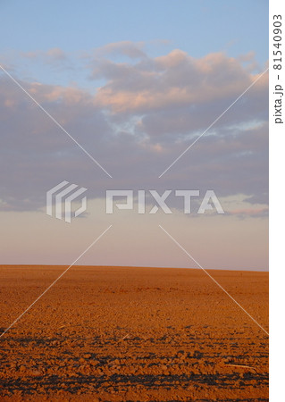 Cloudy evening sky over an empty agricultural field. Bright sunset landscape. 81540903