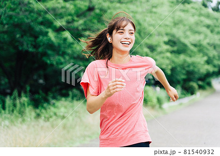 音楽を聴きながらジョギングをする女性 81540932