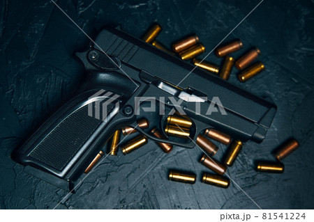 Gun with cartridges on dark concrete table. Gun with cartridges on dark concrete table. 81541224