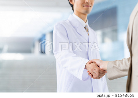 若いビジネスウーマンと握手する白衣の男性 若いビジネスウーマンと握手する白衣の男性 81543659