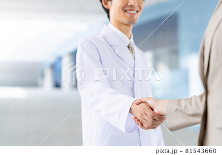 若いビジネスウーマンと握手する白衣の男性 若いビジネスウーマンと握手する白衣の男性 81543660