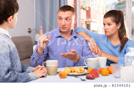 Father and mom scolding son in the kitchen Father and mom scolding son in the kitchen 81544101