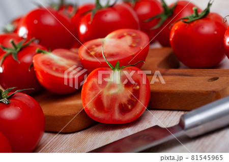 Red tomatoes and knife on wooden cutting board Red tomatoes and knife on wooden cutting board 81545965