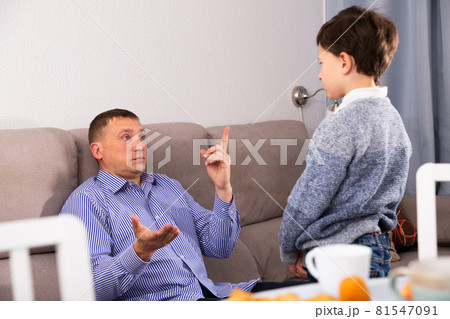 Upset father pointing to mistakes to his son while quarreling 81547091