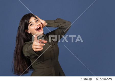 Cropped portrait of young beautiful expressive girl isolated on blue studio background Cropped portrait of young beautiful expressive girl isolated on blue studio background 81548229
