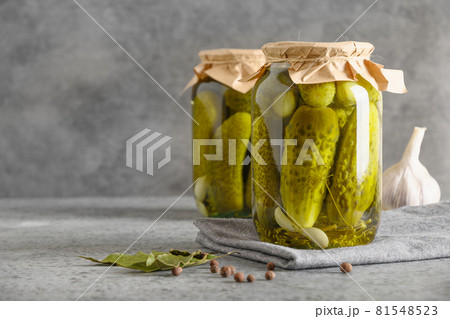 Canned vegetables cucumber in glass jars on grey background. 81548523