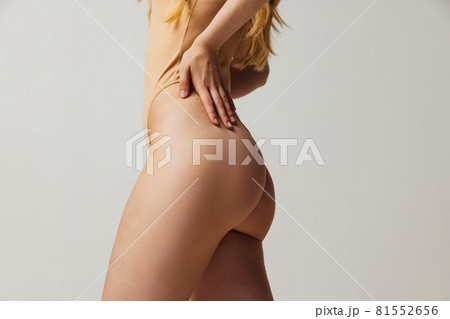Back view of young beautiful slim tanned woman in lingerie posing isolated over light studio background. Natural beauty, wellness, healthy lifestyle concept. Back view of young beautiful slim tanned woman in lingerie posing isolated over light studio background. Natural beauty, wellness, healthy lifestyle concept. 81552656