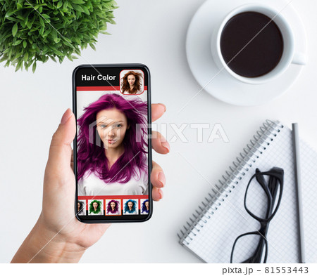 Woman trying new hairstyle via hair simulation mobile app Woman trying new hairstyle via hair simulation mobile app 81553443