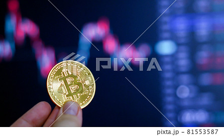 Hand holding golden coin crypto currency stock trade graph backg 81553587