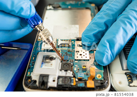 Technician repairing inside of mobile phone by soldering iron. Integrated Circuit. the concept of data, hardware, technology. Technician repairing inside of mobile phone by soldering iron. Integrated Circuit. the concept of data, hardware, technology. 81554038