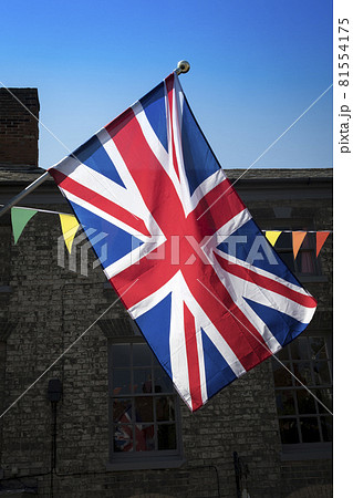 Union Jack and bunting backlit in market town 81554175