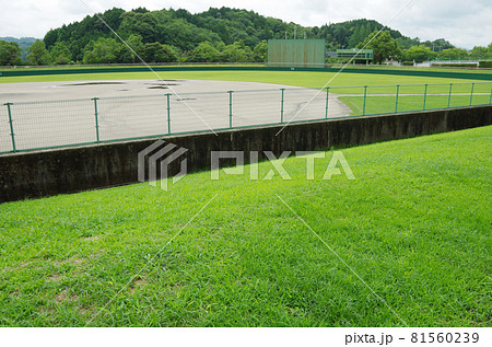 雨上がりで曇天模様の球場のグラウンドに水溜まりが残っている光景 雨上がりで曇天模様の球場のグラウンドに水溜まりが残っている光景 81560239