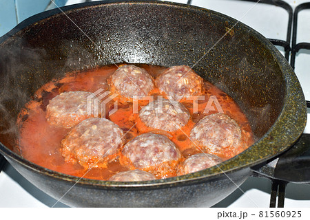 The meatballs are cooked on the stovetop in a frying pan. The meatballs are cooked on the stovetop in a frying pan. 81560925