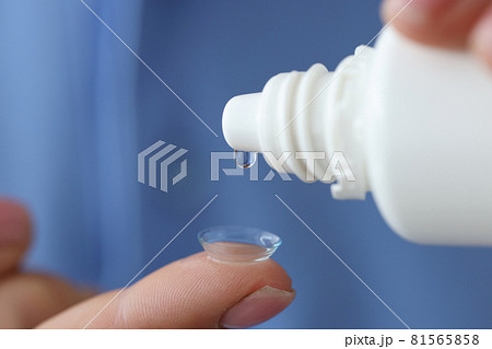 Woman drips liquid into contact lens for eyes closeup Woman drips liquid into contact lens for eyes closeup 81565858