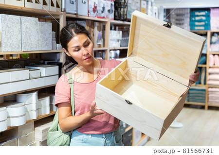 Woman standing with big wooden box in decoration and furniture store Woman standing with big wooden box in decoration and furniture store 81566731