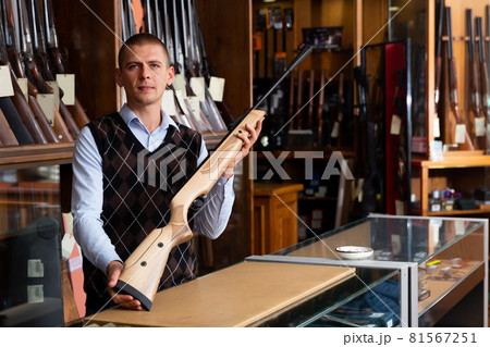 Gun shop salesman with air rifle in hand closeup 81567251