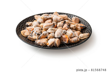 Frozen peeled mussels on a black ceramic plate isolated on a white background. Frozen peeled mussels on a black ceramic plate isolated on a white background. 81568748