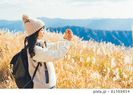 山頂で写真を撮る女性 81569854