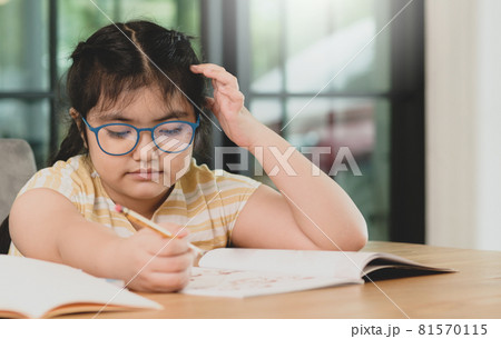 Child girl wearing glasses with pencil in hand studying at home bored expression. Online learning. Child girl wearing glasses with pencil in hand studying at home bored expression. Online learning. 81570115