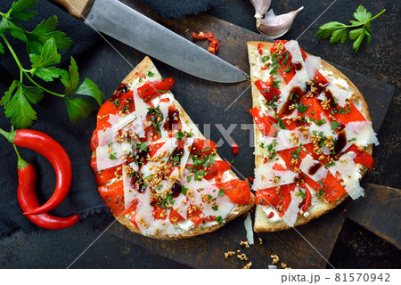 Italian large bruschetta with grilled pointed peppers, chili, pecorino, sesame and cream cheese Italian large bruschetta with grilled pointed peppers, chili, pecorino, sesame and cream cheese 81570942