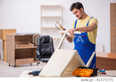 Young male carpenter repairing chair in the office 81573775