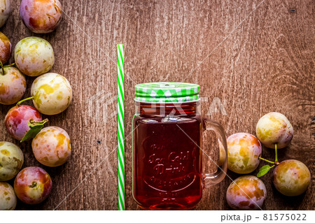 Glass with fresh Plum Juice on vintage wooden background 81575022