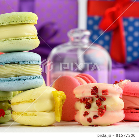 baked macarons with different flavors and rosebuds on a white background, behind gift boxes baked macarons with different flavors and rosebuds on a white background, behind gift boxes 81577500