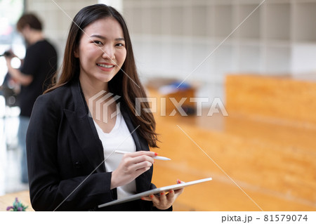 Cute Asian business woman is working with digital tablet pen stylus at office Cute Asian business woman is working with digital tablet pen stylus at office 81579074