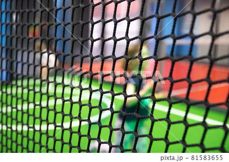 Blurred children are playing behind the net at indoor playground in activity park. 81583655