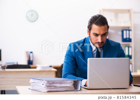 Young male employee and too many work in the office 81584345