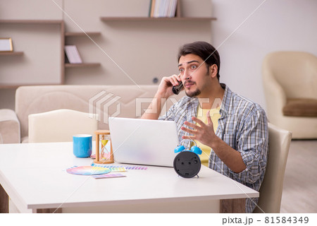 Young male freelancer in time management concept at home 81584349