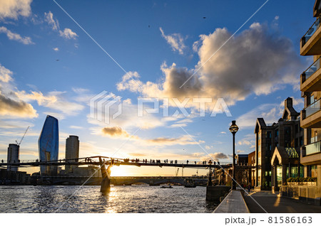 Sunset behind the Millennium Bridge in London, UK with dramatic clouds. It crosses the River Thames with Blackfriars Bridge and the South Bank behind 81586163