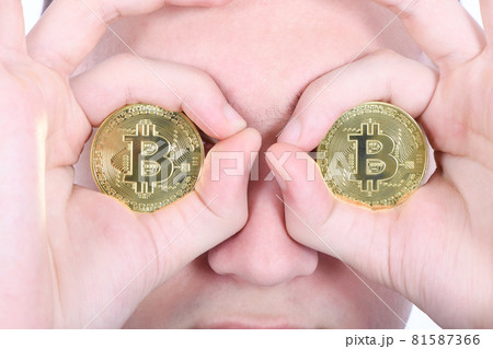 Man keeps the eye instead two golden cryptocurrency bitcoin in hands 81587366
