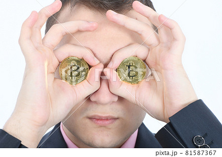 Man keeps the eye instead two golden cryptocurrency bitcoin in hands 81587367