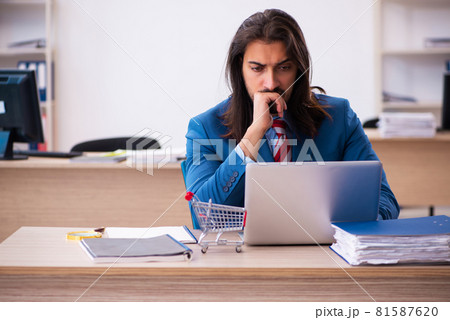 Young male employee in ecommerce concept in the office Young male employee in ecommerce concept in the office 81587620