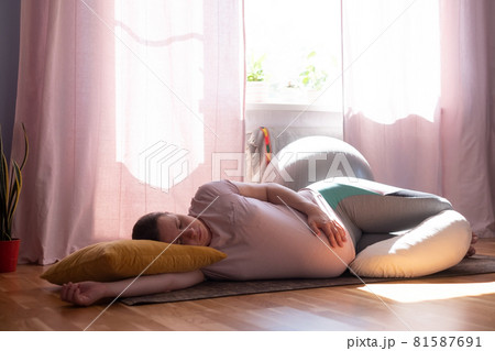 Young caucasian pregnant yoga woman resting after working out in prenatal Shavasana 81587691