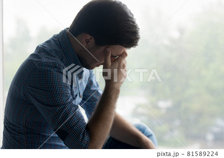 Depressed frustrated millennial man touching head, covering face 81589224